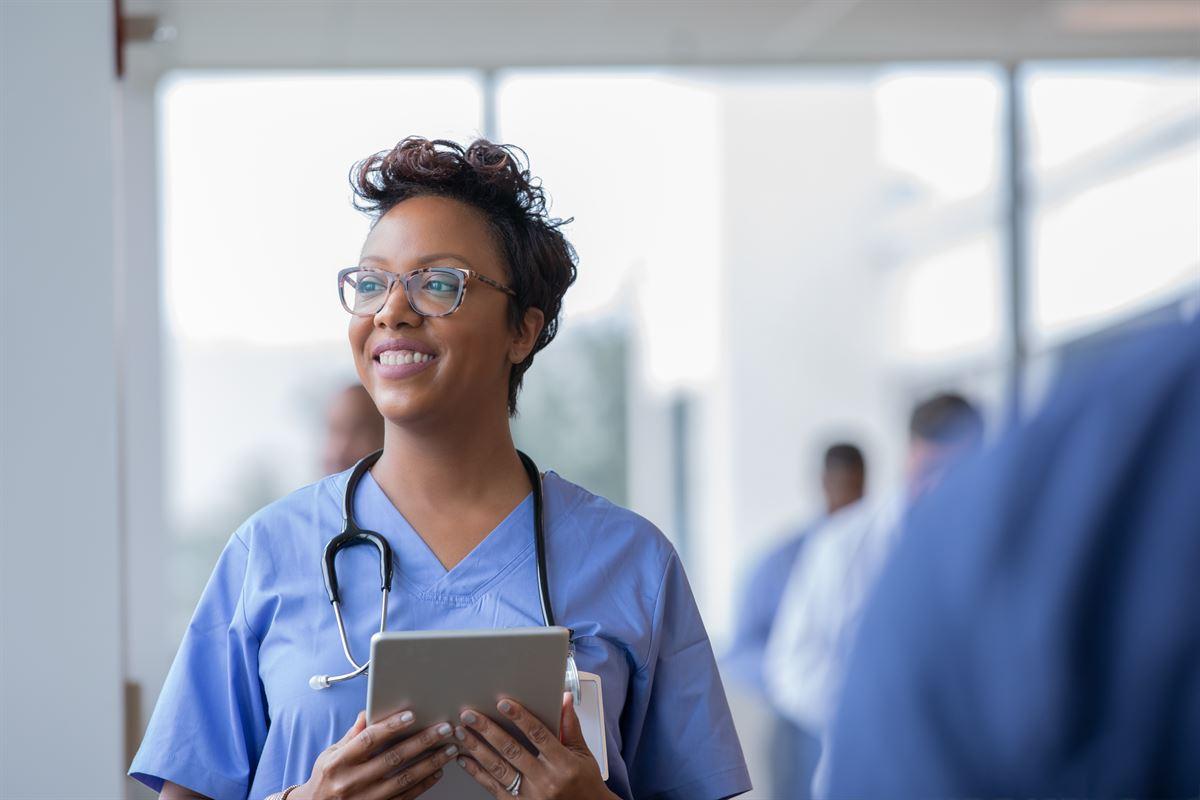African American nurse with an tablet looking out the window